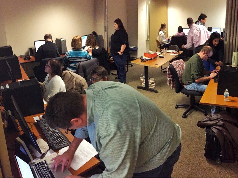 A room with computers, with people paired up, testing a website