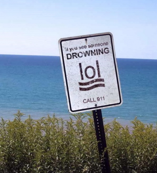 A sign at a cliff stating: if you see someone drowning, call 911