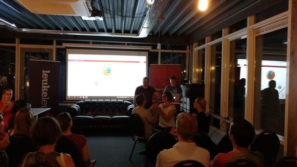 Bram Duvigneau and Vincent van Itallie standing in front of the meetup room, facing a crowd of people.