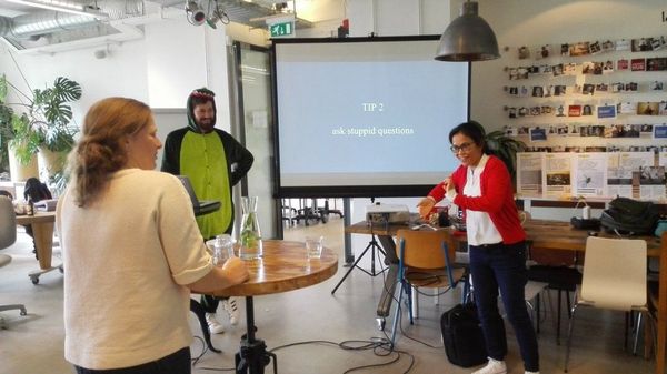 On the left, Michiel Bijl in his usual dinosaur onesie. To the right, Eva Westerhoff communicates using sign language.