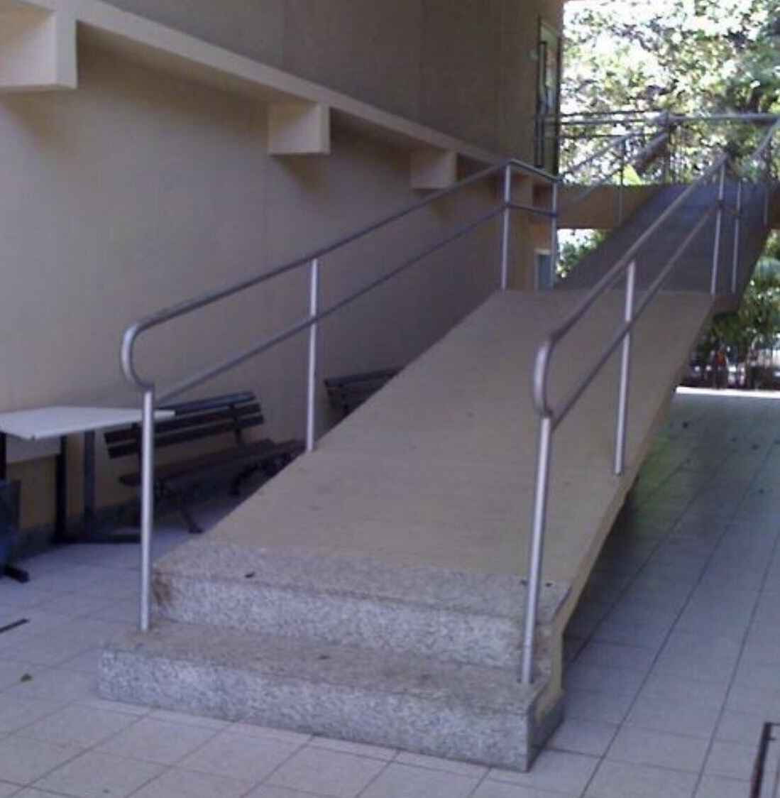A long ramp that is not accessible because it starts with 2 steps.