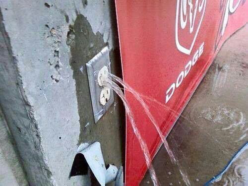 A power outlet has water pouring out.